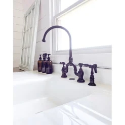 Kingston Brass Tudor Bridge Deck Mount Kitchen Faucet with Brass Sprayer