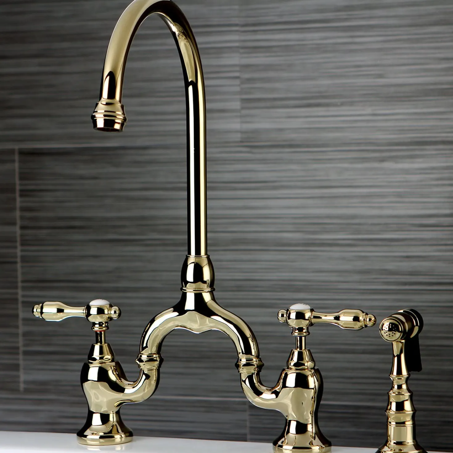 Kingston Brass Tudor Bridge Deck Mount Kitchen Faucet with Brass Sprayer