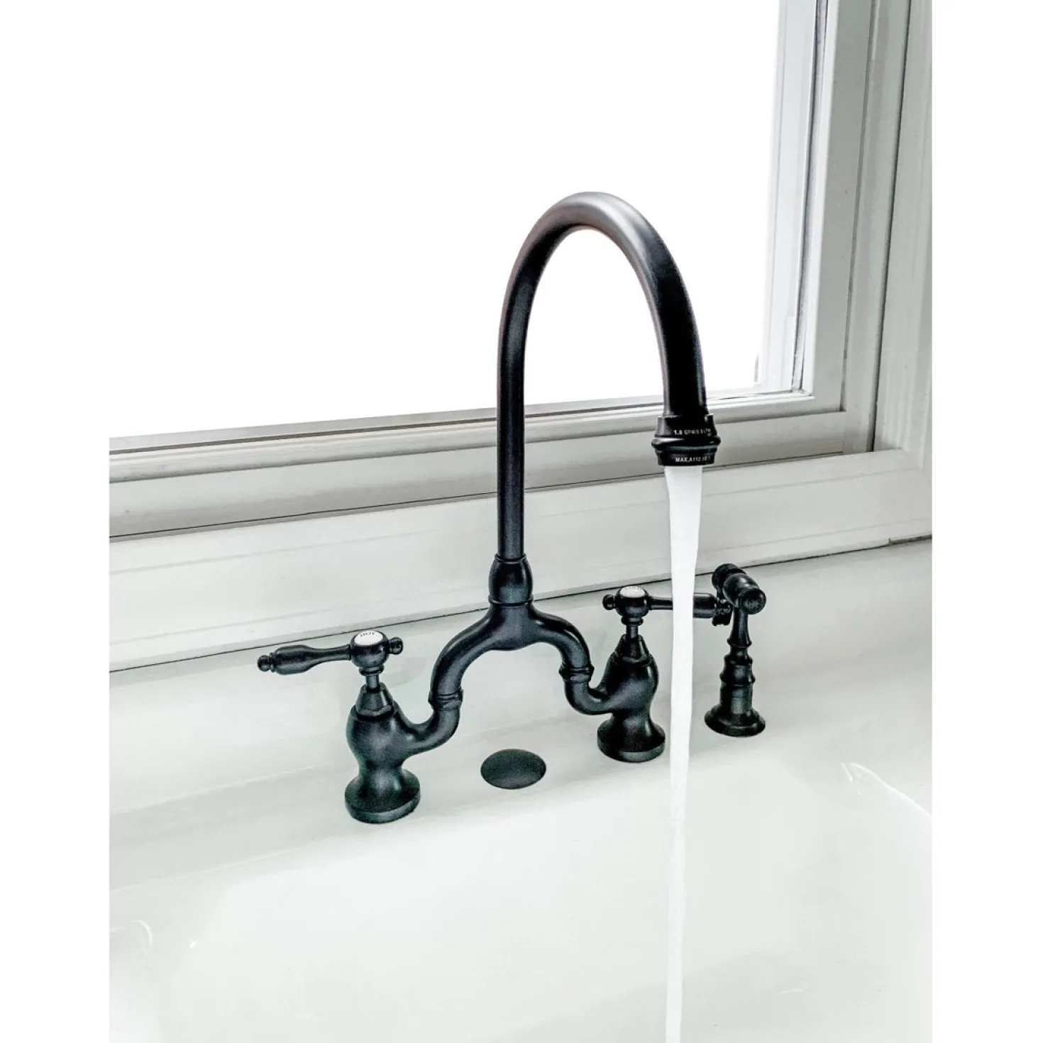 Kingston Brass Tudor Bridge Deck Mount Kitchen Faucet with Brass Sprayer
